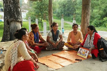 A group of five women sit together in Bangladesh